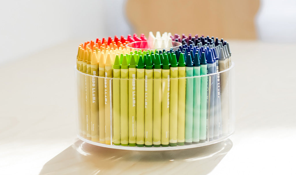 A set of acrylic pencils in one round clear rotating pencil organizer on the table