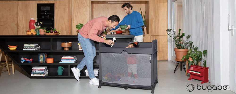 parents preparing dinner while child plays in bugaboo stardust play yard